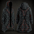 A hooded longline coat shown from the front and back on a dark studio background. The garment has an all-over ornate symmetrical pattern in black, gray, white, and red, with a black hood and black open front on the front view.