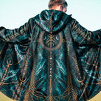 A man viewed from behind wearing a hooded robe with a dark teal and black marbled pattern and intricate gold celestial and geometric designs.