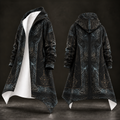 A long hooded robe-style coat shown from the front and back on a dark mannequin form. The garment is predominantly black with an intricate blue-gray and gold ornamental pattern, a white inner lining visible on the front, and a full front zipper.
